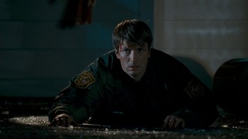Movie still from “Slither” (2006), directed by James Gunn – A man with a patch on his face is laying on the ground; Medium shot, Overhead angle