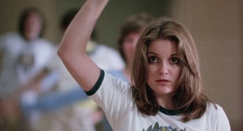 Movie still from “Smile” (1975), directed by Michael Ritchie – A young woman is holding her arm up in the air; Close Up shot, Low angle