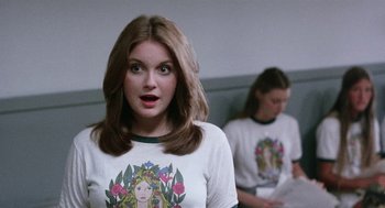 Movie still from “Smile” (1975), directed by Michael Ritchie – A woman with a surprised look standing next to another woman; Close Up shot, Over the shoulder angle