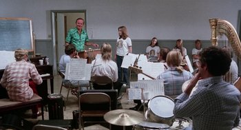 Movie still from “Smile” (1975), directed by Michael Ritchie – A group of people sitting in a room with musical instruments; Wide shot, Over the shoulder angle