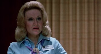 Movie still from “Smile” (1975), directed by Michael Ritchie – An older woman with blonde hair wearing a blue shirt; Close Up shot, Over the shoulder angle