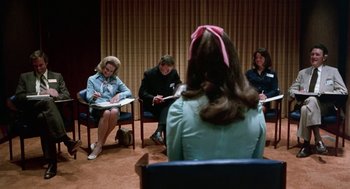 Movie still from “Smile” (1975), directed by Michael Ritchie – A group of people sitting in a circle reading papers; Medium shot, Over the shoulder angle