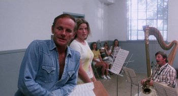 Movie still from “Smile” (1975), directed by Michael Ritchie – A group of people sitting in front of musical instruments; Medium shot, Low angle