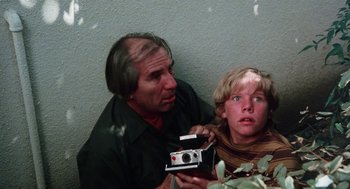 Movie still from “Smile” (1975), directed by Michael Ritchie – A man and a boy are holding a camera; Medium shot, Low angle