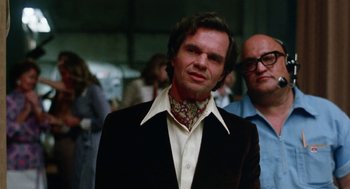 Movie still from “Smile” (1975), directed by Michael Ritchie – A man in a black jacket and a white shirt; Medium shot, Low angle