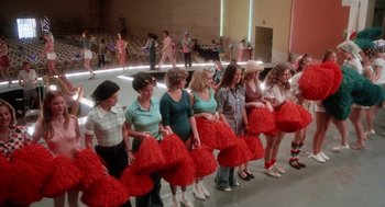 Movie still from “Smile” (1975), directed by Michael Ritchie – A group of women standing next to each other holding pom poms; Wide shot, High angle