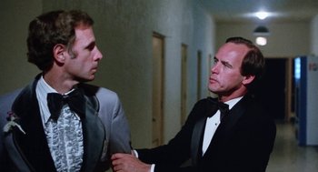 Movie still from “Smile” (1975), directed by Michael Ritchie – A man in a suit and a man in a tie talking to each other; Close Up shot, Low angle