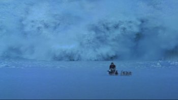 Movie still from “Smilla's Sense of Snow” (1997), directed by Bille August – A person on a snowmobile in the snow near a large wave; Extreme Wide shot, High angle