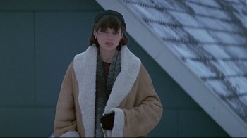 Movie still from “Smilla's Sense of Snow” (1997), directed by Bille August – A woman in a brown coat standing in front of a building; Medium shot, Over the shoulder angle
