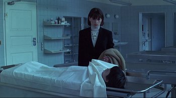 Movie still from “Smilla's Sense of Snow” (1997), directed by Bille August – A woman standing next to a man laying on a hospital bed; Medium shot, Low angle