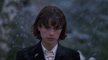 Movie still from “Smilla's Sense of Snow” (1997), directed by Bille August – A young woman in a black suit with snow on her hair; Close Up shot, Low angle