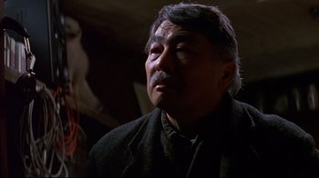 Movie still from “Smilla's Sense of Snow” (1997), directed by Bille August – An older man in a black jacket is looking at the camera; Close Up shot, Low angle