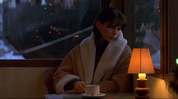 Movie still from “Smilla's Sense of Snow” (1997), directed by Bille August – A woman sitting at a table drinking a cup of coffee; Medium shot, High angle