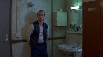 Movie still from “Smilla's Sense of Snow” (1997), directed by Bille August – A man standing in front of a bathroom mirror; Medium shot, Low angle
