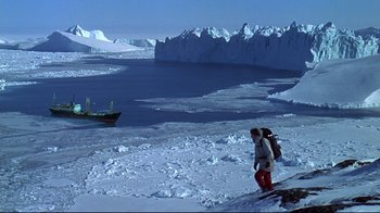 Movie still from “Smilla's Sense of Snow” (1997), directed by Bille August – A man standing on the snow next to a body of water; Extreme Wide shot, High angle