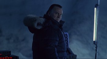 Movie still from “Smilla's Sense of Snow” (1997), directed by Bille August – A man in a black jacket is standing in the dark; Medium shot, Low angle