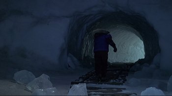 Movie still from “Smilla's Sense of Snow” (1997), directed by Bille August – A person walking in a snow cave at night; Wide shot, High angle