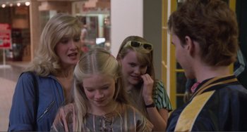 Movie still from “Smooth Talk” (1985), directed by Joyce Chopra – A group of people standing next to each other in a room; Medium shot, Over the shoulder angle