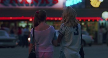Movie still from “Smooth Talk” (1985), directed by Joyce Chopra – Two young girls holding hands while standing on the street; Medium shot, Over the shoulder angle