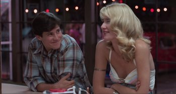 Movie still from “Smooth Talk” (1985), directed by Joyce Chopra – A man and a woman sitting next to each other at a table; Medium shot, Low angle