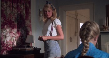 Movie still from “Smooth Talk” (1985), directed by Joyce Chopra – A woman in a white t - shirt and blue jean shorts; Medium shot, Over the shoulder angle
