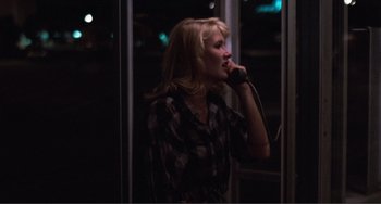 Movie still from “Smooth Talk” (1985), directed by Joyce Chopra – A woman talking on a cell phone while standing in a room; Medium shot, Over the shoulder angle