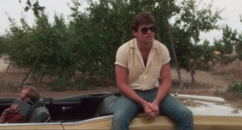 Movie still from “Smooth Talk” (1985), directed by Joyce Chopra – A man sitting on the back of a boat; Medium shot, Low angle