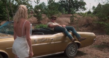 Movie still from “Smooth Talk” (1985), directed by Joyce Chopra – A man and a woman sitting on the hood of an old car; Wide shot, Over the shoulder angle