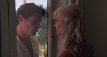 Movie still from “Smooth Talk” (1985), directed by Joyce Chopra – A man and a woman standing next to each other in front of a window; Close Up shot, Low angle