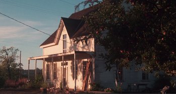 Movie still from “Smooth Talk” (1985), directed by Joyce Chopra – An old white house sitting in the middle of a street; Extreme Wide shot, Low angle