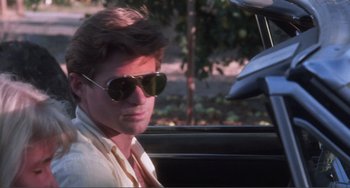 Movie still from “Smooth Talk” (1985), directed by Joyce Chopra – A man wearing sunglasses sitting in the back of a car; Close Up shot, Over the shoulder angle