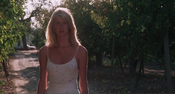 Movie still from “Smooth Talk” (1985), directed by Joyce Chopra – A woman in a white dress standing in a forest; Medium shot, Low angle