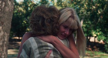Movie still from “Smooth Talk” (1985), directed by Joyce Chopra – A woman hugging another woman in a field; Close Up shot, Over the shoulder angle