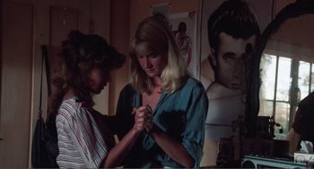 Movie still from “Smooth Talk” (1985), directed by Joyce Chopra – Two women are holding hands in a room; Medium shot, Over the shoulder angle