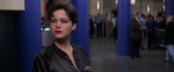 Movie still from “Snake Eyes” (1998), directed by Brian De Palma – A woman with red lipstick is standing in a room; Close Up shot, Over the shoulder angle