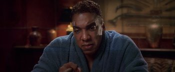 Movie still from “Snake Eyes” (1998), directed by Brian De Palma – A person wearing a robe; Close Up shot, Low angle