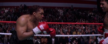 Movie still from “Snake Eyes” (1998), directed by Brian De Palma – A man wearing a red boxing glove in a boxing ring; Medium shot, High angle