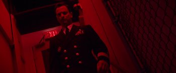 Movie still from “Snake Eyes” (1998), directed by Brian De Palma – A man in a military uniform standing in a room; Medium shot, Low angle