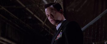 Movie still from “Snake Eyes” (1998), directed by Brian De Palma – A person wearing a suit and tie; Close Up shot, Low angle