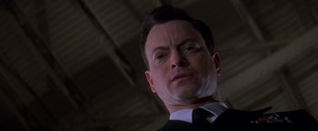 Movie still from “Snake Eyes” (1998), directed by Brian De Palma – A man in a suit and tie; Close Up shot, Low angle