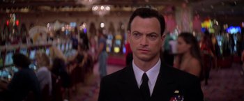 Movie still from “Snake Eyes” (1998), directed by Brian De Palma – A person wearing a suit and tie; Close Up shot, Low angle