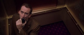 Movie still from “Snake Eyes” (1998), directed by Brian De Palma – A man holding a cell phone up to his ear; Close Up shot, High angle