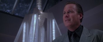 Movie still from “Snake Eyes” (1998), directed by Brian De Palma – A person wearing a suit and tie; Close Up shot, Low angle