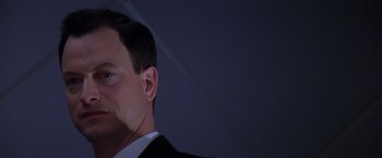 Movie still from “Snake Eyes” (1998), directed by Brian De Palma – A person wearing a suit and tie; Close Up shot, Low angle