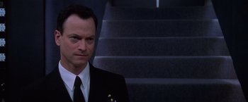 Movie still from “Snake Eyes” (1998), directed by Brian De Palma – A person wearing a suit and tie; Close Up shot, Low angle