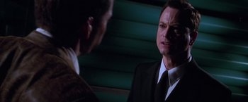 Movie still from “Snake Eyes” (1998), directed by Brian De Palma – A man in a suit and tie talking to another man in a suit and tie; Close Up shot, Over the shoulder angle