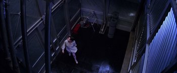 Movie still from “Snake Eyes” (1998), directed by Brian De Palma – A woman in a white dress walking down a hall way; Wide shot, Overhead angle