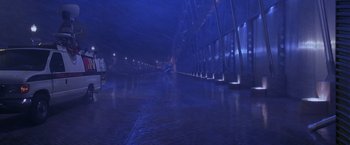 Movie still from “Snake Eyes” (1998), directed by Brian De Palma – A person is walking on a wet road at night; Extreme Wide shot, High angle