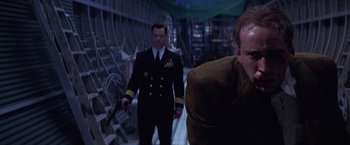 Movie still from “Snake Eyes” (1998), directed by Brian De Palma – Two men in military uniforms are walking in a building; Medium shot, Low angle