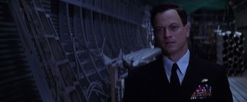 Movie still from “Snake Eyes” (1998), directed by Brian De Palma – A man standing in front of a bunch of wires; Close Up shot, Low angle